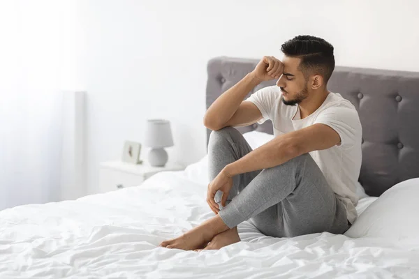 Concepto de apatía. Triste joven árabe sentado en la cama en casa — Foto de Stock