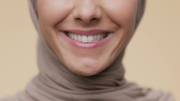 Dental hygiene concept. Close up shot of unrecognizable arab woman smiling to camera, demonstrating perfect white teeth — Stock Video