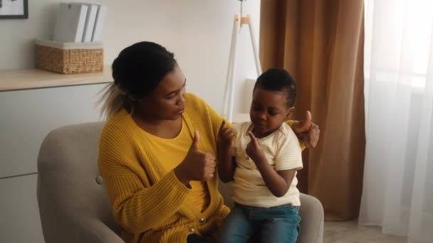 Caring Black Mother Teaching Her Little Son Counting On Fingers At Home — Stok Video