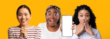 Emotional multiethnic girlfriends posing with mobile phone, mockup