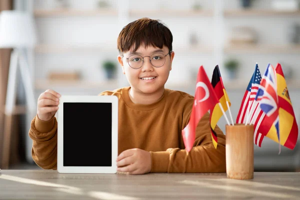 Positive chubby asian boy showing digital tablet with blank screen — Foto Stock