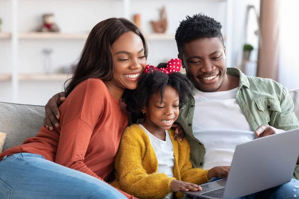 Cheerful Black Family Of Three With Little Daughter Using Laptop At Home — Stockfoto