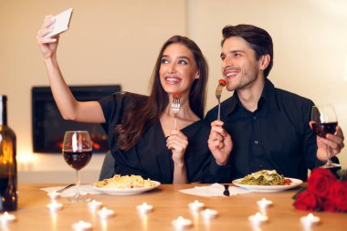 Smiling woman taking selfie with boyfriend on a date