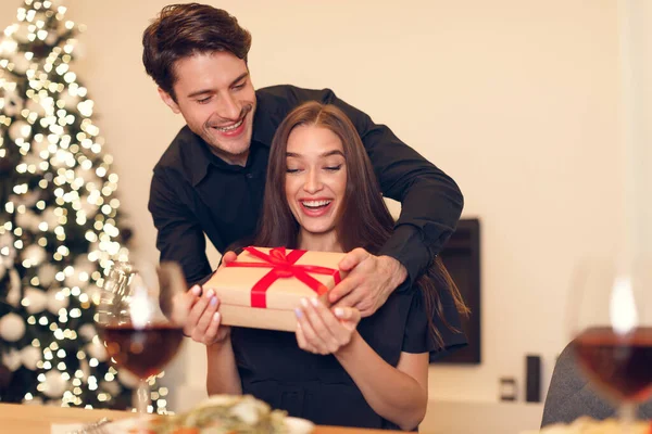 Young man giving gift box to his girlfriend — стоковое фото