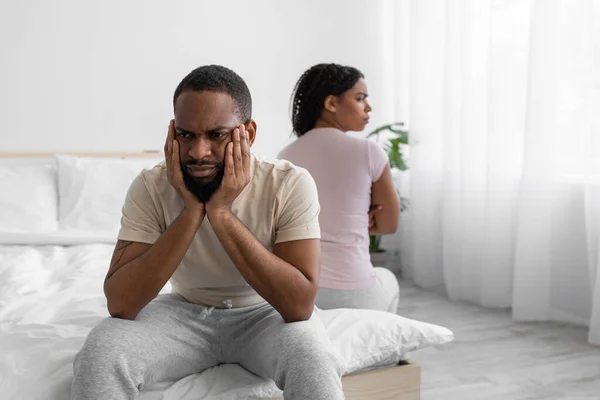 Unhappy offended young african american husband ignores wife, sit on comfortable bed back to back — Stockfoto