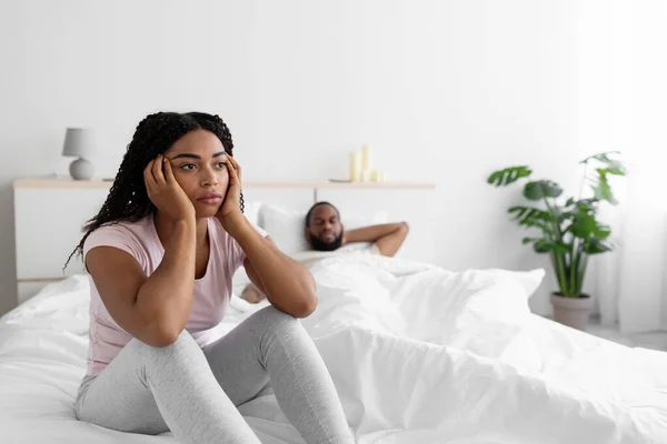 Droevige jonge Afro-Amerikaanse vrouw is verdrietig en negeert haar man na schandaal in comfortabel bed — Stockfoto