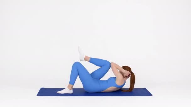 Deportiva mujer haciendo codo a rodilla abdominales crujidos ejercicio mientras se entrena en el estudio — Vídeos de Stock