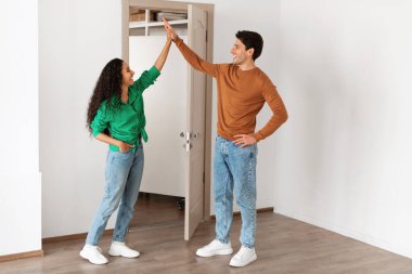 Happy man and woman giving high five celebrating moving day