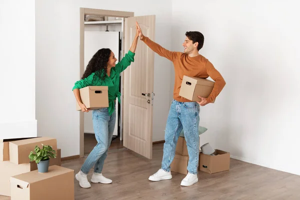 Happy man and woman giving high five celebrating moving day — Stock Photo, Image