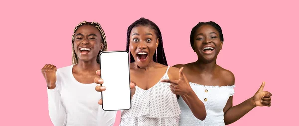 Ελκυστικές αφρικανικές αμερικανικές γυναίκες δείχνουν smartphone με λευκή οθόνη — Φωτογραφία Αρχείου