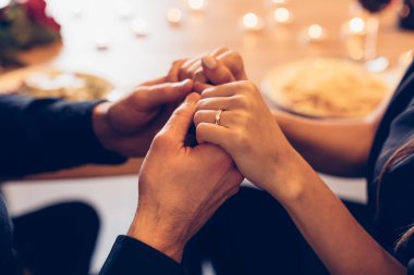 Couple having dinner, focus on hands and ring