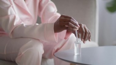 Eline serum süren Afrikalı kadın içeride deriyi nemlendiriyor, kırpılıyor.