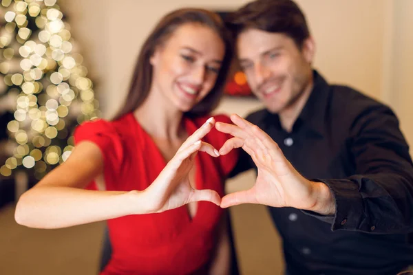 Happy smiling couple making heart shape with hands, — Foto de Stock