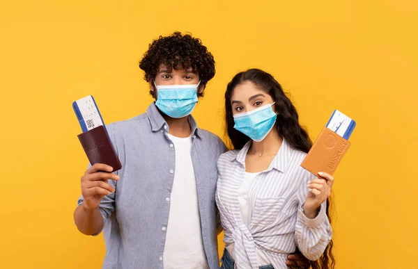 Young indian couple wearing protective face masks, holding passports and flight tickets — 스톡 사진