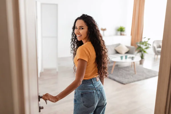 Back view of excited young woman walking in apartment — Foto Stock