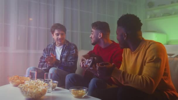 Group of happy multiethnic guys friends playing guitar and singing together, having fun at home in evening, zoom in — Αρχείο Βίντεο