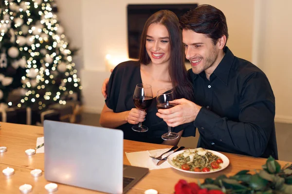 Pariskunta, jolla on videocall kannettavan tietokoneen juominen viiniä — kuvapankkivalokuva