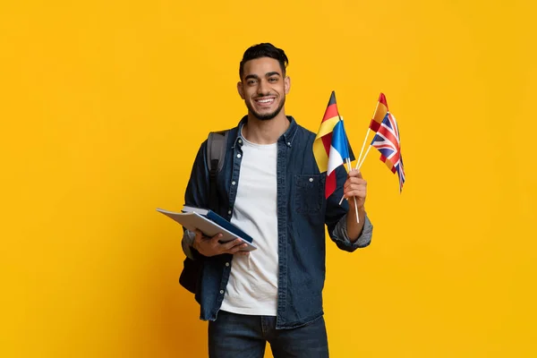 Positiver Student aus dem Nahen Osten zeigt Flaggen verschiedener Länder — Stockfoto