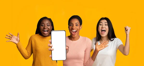 Emotional multiracial young women posing with modern smartphone, mockup — Φωτογραφία Αρχείου