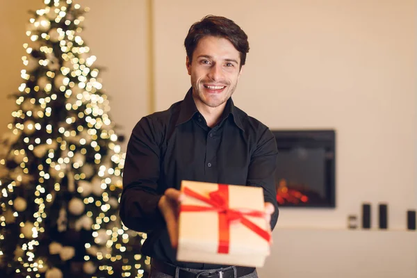 Excited man holding gift box, showing to camera — 스톡 사진