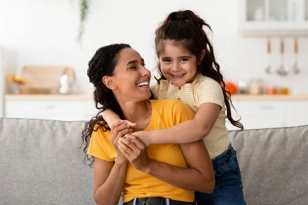 Feliz joven árabe mamá y su lindo preadolescente hija abrazando en casa —  Fotos de Stock