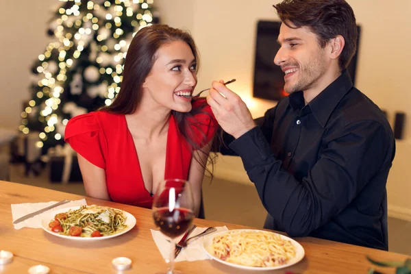 Handsome guy feeding his woman with pasta — Fotografia de Stock