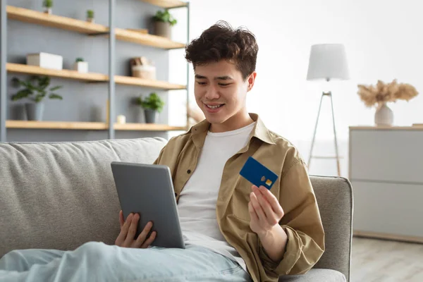 Le asiatisk kille som visar kreditkort hemma — Stockfoto