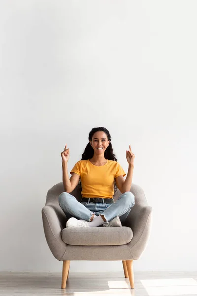 Look At This. Happy Brunette Lady Sitting In Armchair And Pointing Up — Foto de Stock