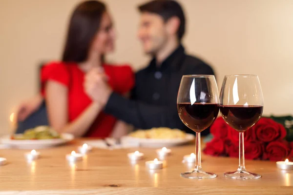 Άντρας που τρώει με γυναίκα, να επικεντρωθεί σε ποτήρια κρασιού — Φωτογραφία Αρχείου