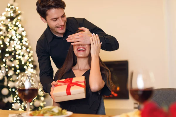Young man giving box to woman, covering eyes — Foto de Stock