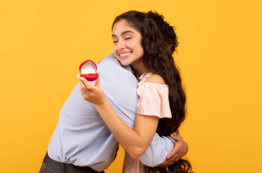 Happy indian lady with engagement ring embracing her future husband, saying YES to his marriage proposal