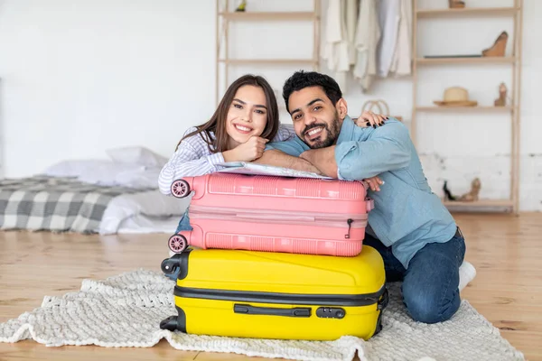 Concepto de viaje. Pareja feliz apoyada en maletas y sonriendo a la cámara, lista para las vacaciones en el extranjero — Foto de Stock