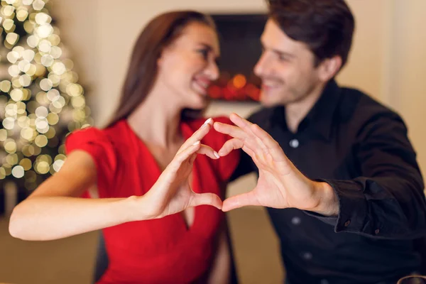 Happy smiling couple making heart shape with hands — Photo