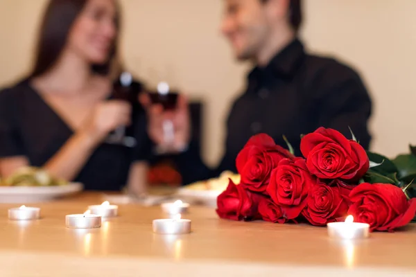 Homem jantando com mulher, foque em rosas vermelhas — Fotografia de Stock