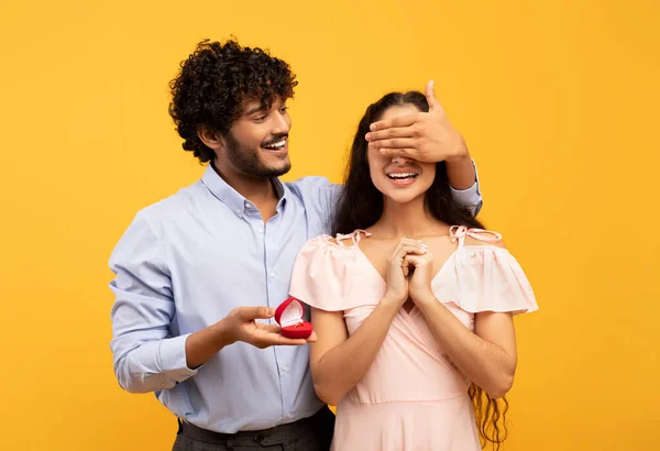 Engagement, romantic concept. Loving indian man making proposal to his lovely girlfriend, closing ladys eyes with hand — Foto de Stock