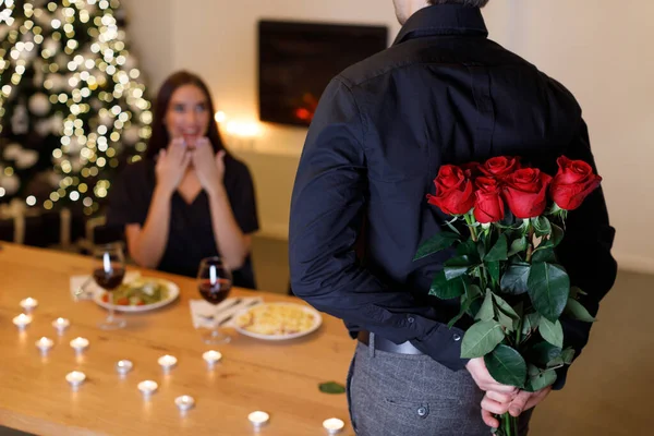 Junger Mann schenkt Frau rote Rosen — Stockfoto