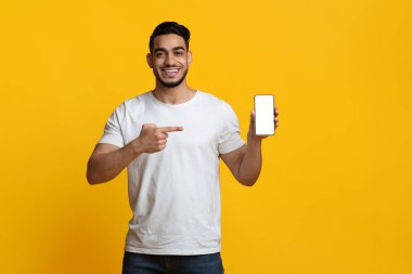 Mutlu Arap milenyum adamı boş ekranlı akıllı telefon gösteriyor