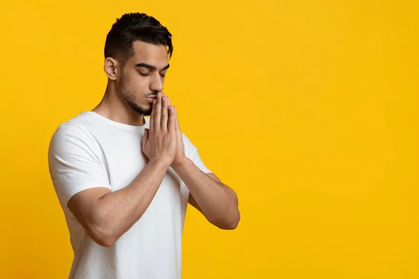 Religioso joven de Oriente Medio rezando en amarillo — Foto de Stock