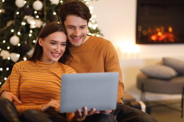 gülümseyen genç bir çift dizüstü evde kullanma