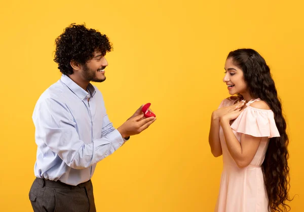 Выходи за меня замуж. Счастливый индиец предлагает показать коробку с обручальными кольцами и попросить подружку стать его женой. — стоковое фото