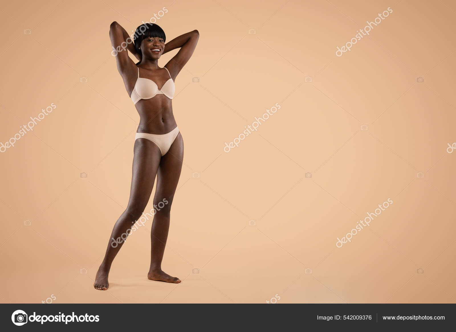 Happy attractive black lady posing in underwear on beige Stock