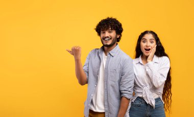 Omg, check this. Emotional indian guy pointing finger at free space, surprised lady looking at camera, panorama