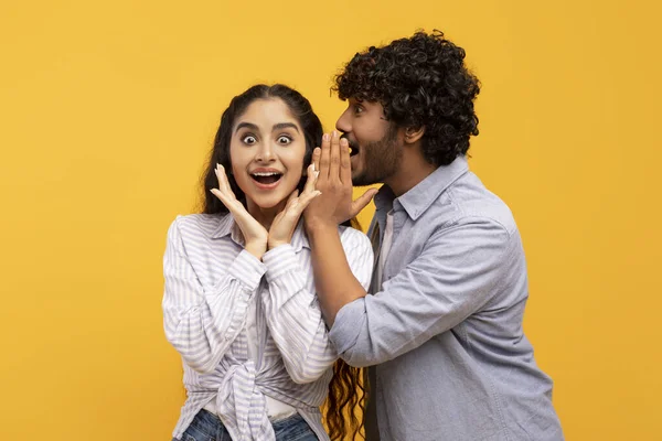 Σοκ, κουτσομπολιό, να μοιράζεσαι συμβουλές. Νεαρός Ινδιάνος να ψιθυρίζει στην κυρία στο αυτί, έκπληκτη γυναίκα με ανοιχτό στόμα — Φωτογραφία Αρχείου