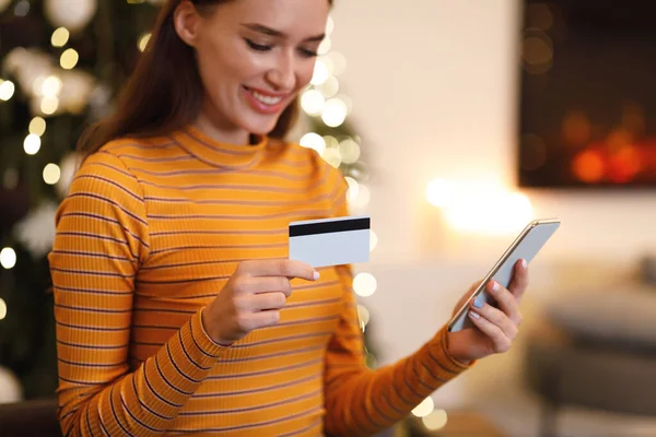 Happy woman holding debit credit card, using cellphone