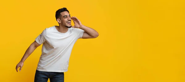 Excited middle eastern guy screaming towards copy space — Stockfoto