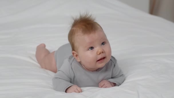 Детское развитие. Симпатичный новорожденный лежит на животе — стоковое видео