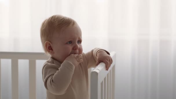 Baby Dinething. Portret de plâns copil băiat în picioare în pat la domiciliu, — Videoclip de stoc