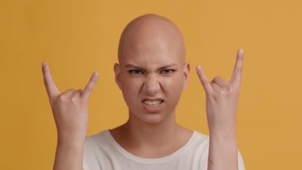 Chauve femme montrant rock geste partie s'amuser, fond jaune — Video