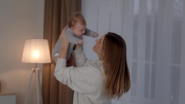 Happy Motherhood. Cheerful Young Woman Playing With Her Newborn Baby At Home — Video