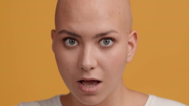 Skin-Headed Woman Turning Head To Camera And Smiling, Yellow Background — Stock Video